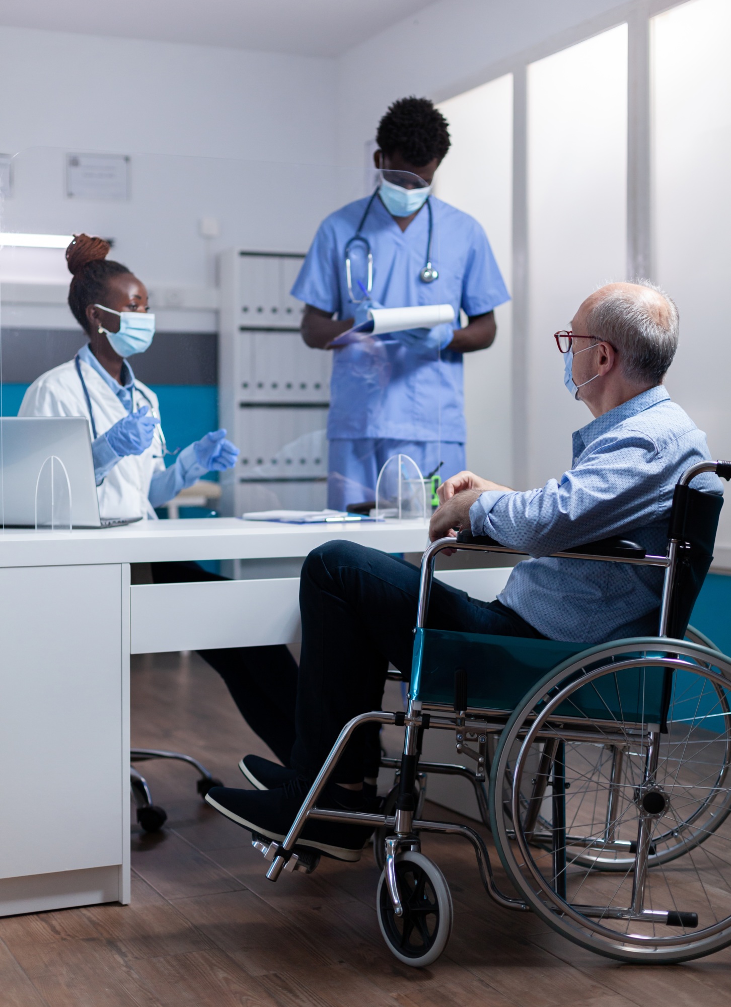 Patient in a Wheelchair Receiving Care, with Masks On